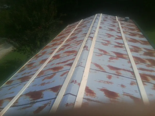 Rusted metal roof panels with new wood purlins before replacement — Storm Damage Roof Repair in Sprague by Roofing Brothers